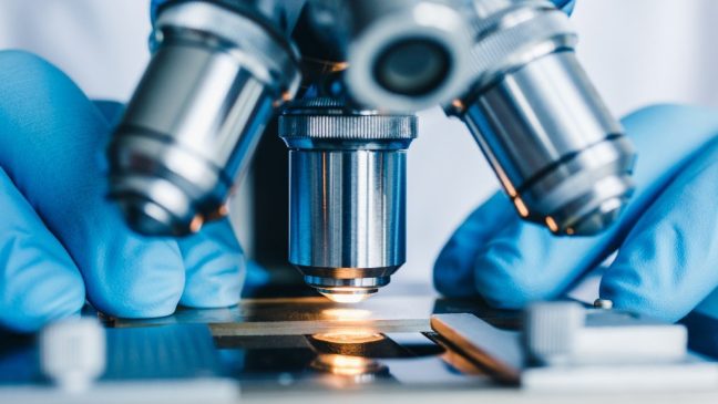 Close-up shot of microscope with metal lens at laboratory